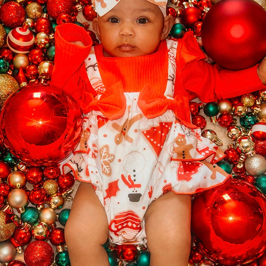 Syllva-Gwen is registered to the contest to win money with this photo: baby, background, celebration, christmas, clothing, cute, decorations, face, festive, gold, green, hands, headband, holiday, infant, legs, ornaments, portrait, red, smile