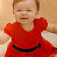 Aliyah is registered to the contest to win money with this photo: baby, child, girl, red_dress, smile, happy, sitting, indoors, portrait, cute, hair_tie, black_belt, polka_dot_background, soft_surface, infant, toddler, clothing, expression, funny_face, person