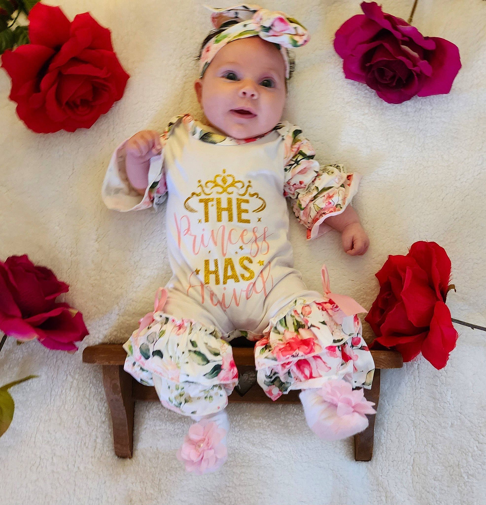 Alondra is registered to the contest to win money with this photo: baby, baby_products, baby_toddler_clothing, child, clothing, fashion_accessory, font, happy, hat, head, headgear, headwear, person, petal, pink, plant, rose, sitting, skin, sleeve