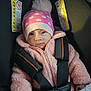 baby, infant, child, car_seat, beanie, pom_pom, pink_jacket, harness, buckle, warning_label, seat_belt, portrait, closeup, cozy, mittens, soft_texture, wide_eyed, face, winter, bundle