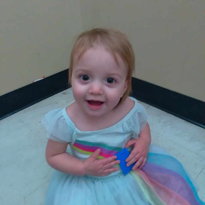 Harmony is registered to the contest to win money with this photo: baby, bodypart, clothing, costume, dress, eveningdress, face, finger, formalwear, hand, happy, head, indoors, laughing, mouth, person, photography, portrait, smile, wrist