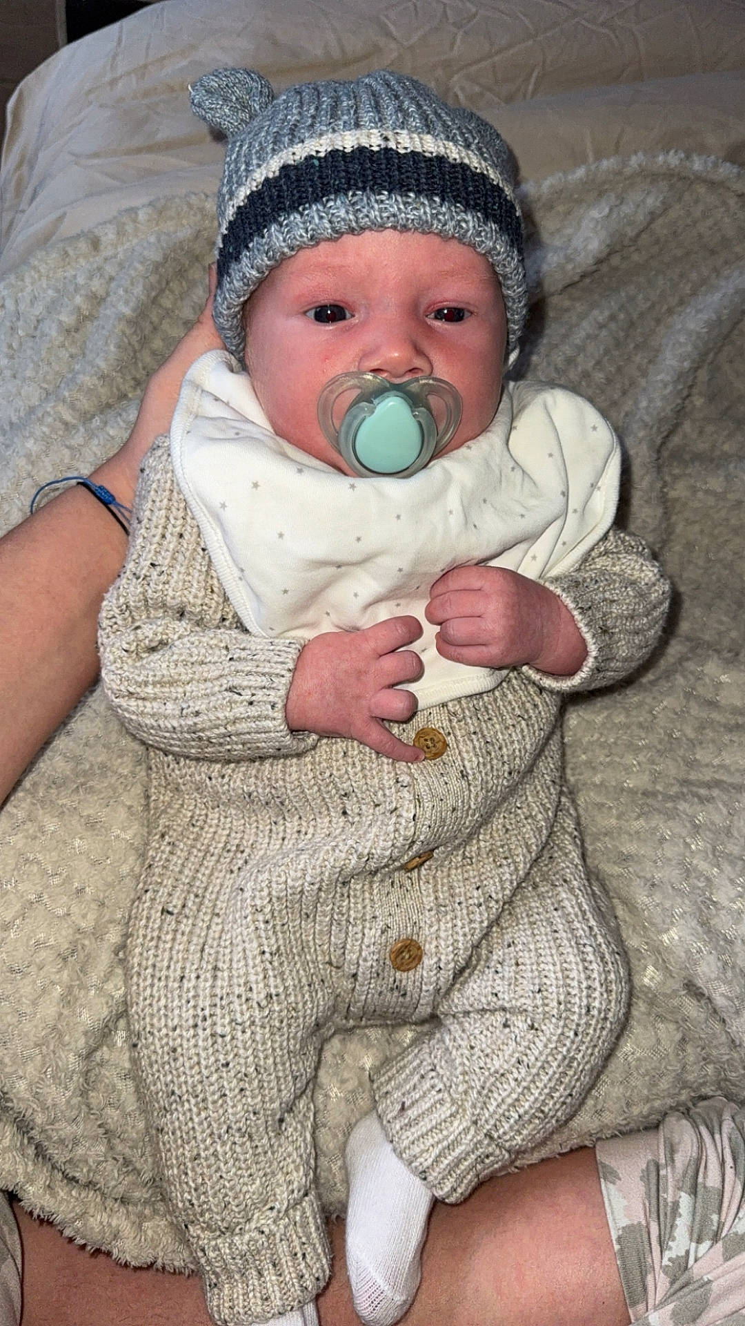 baby, beanie, bodypart, bonnet, cap, clothing, couch, face, furniture, glove, hat, head, hosiery, knitwear, newborn, person, photography, portrait, sock, sweater