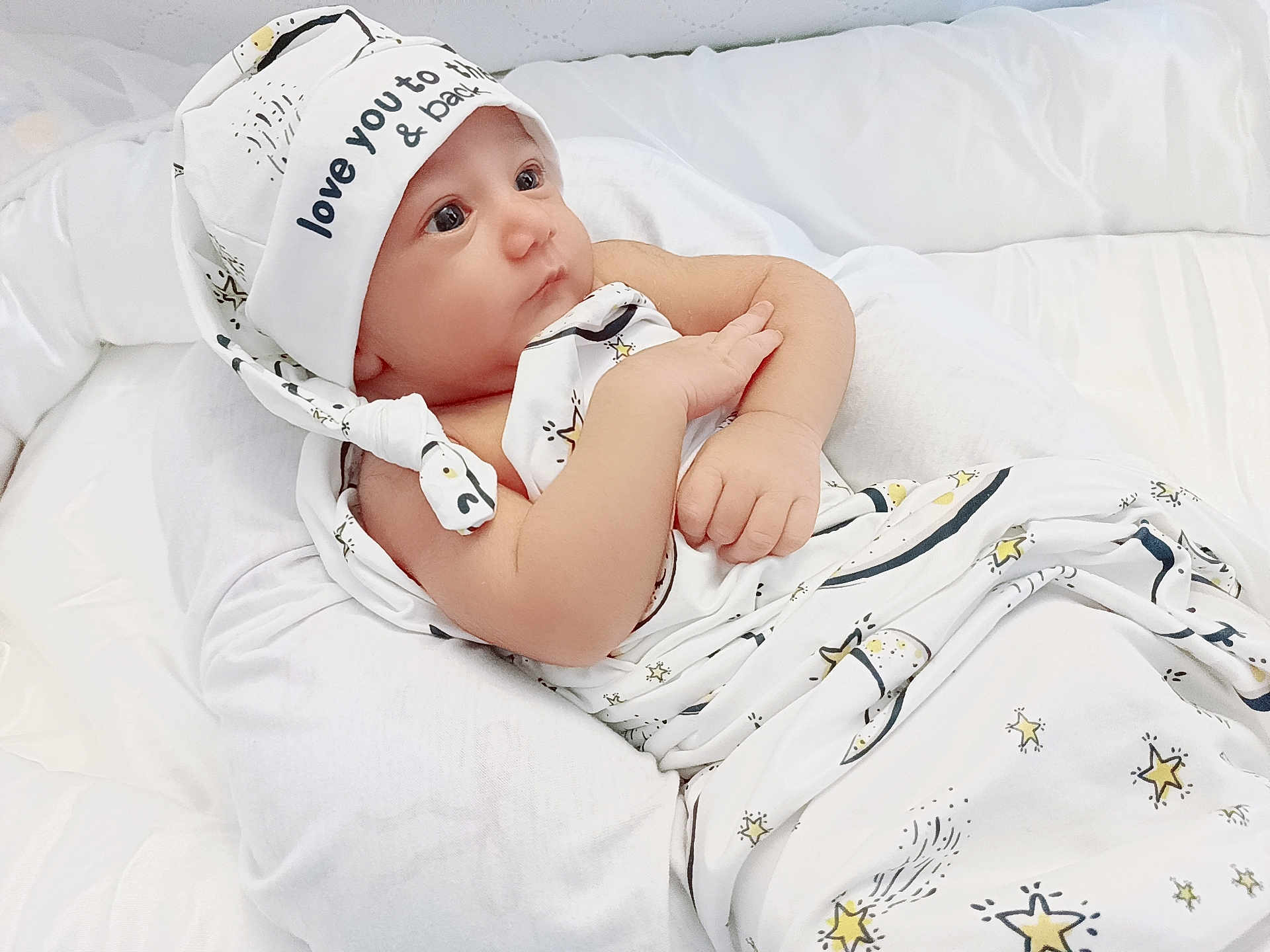 Ayzal Furqan joined the competition — help win amazing prizes! baby, infant, swaddled, blanket, hat, stars, white, cushion, soft, sleeping_bag, newborn, portrait, cute, child, resting, indoors, peaceful, wrapped, closeup, skin