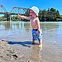 Asher joined the competition — help win amazing prizes! barefoot, bridge, child, daytime, expression, happy, hat, nature, outdoor, play, river, sand, shorts, sky, summer, sunny, toddler, trees, water, water_ripples