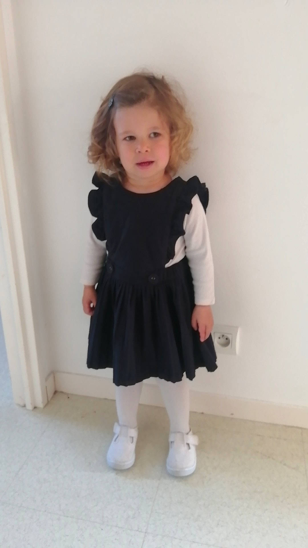 Lola participe au concours pour gagner de l'argent avec cette photo : baby_toddler_clothing, day_dress, dress, embellishment, face, fashion_design, formal_wear, hair, head, human_body, human_leg, iris, knee, one_piece_garment, outerwear, pattern, person, sleeve, sock, toddler