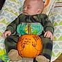 baby, sleeping, pumpkin, baby_rocker, cozy_clothing, plaid, handwritten_text, thankful, orange, footwear, indoor, child, infant, wooden_floor, patterned_fabric, cute, peaceful, festive, decorated_pumpkin, drawing