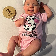 Charlotte is registered to the contest to win money with this photo: baby, infant, smiling, onesie, headband, bow, milestone_sign, number_three, months_text, lying_down, blanket, pink, legs, arms, toes, portrait, closeup, skin, cute, nursery