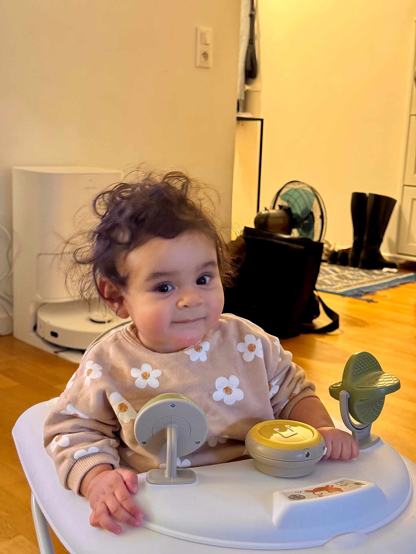 Alya a rejoint le concours — aidez-le/la à gagner de superbes lots ! toddler, baby_walker, child, indoor, curly_hair, flower_pattern, sweater, toy, smile, face, hand, wooden_floor, boots, fan, rug, furniture, home, person, play, cute