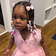 Milan is registered to the contest to win money with this photo: child, girl, pink_dress, braids, beads, butterfly, tutu, floor, indoors, curious, cute, person, portrait, hair_accessories, young_child, wood_floor, cabinet, decor, fashion, cute_outfit