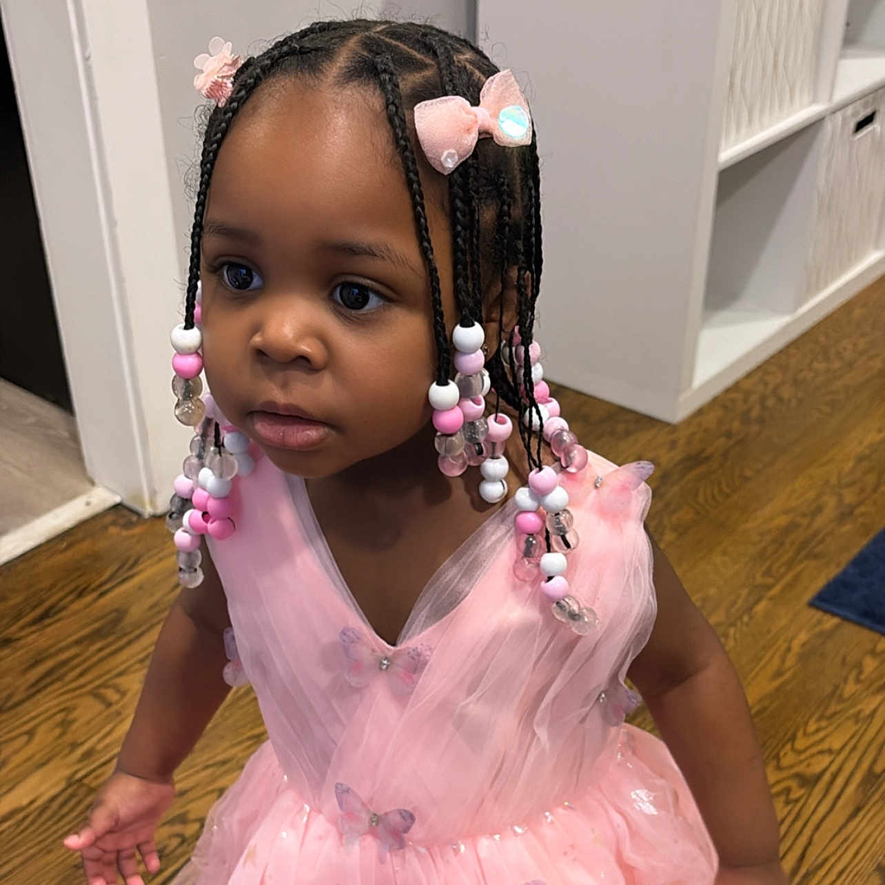 Milan is registered to the contest to win money with this photo: beads, braids, butterfly, cabinet, child, curious, cute, cute_outfit, decor, fashion, floor, girl, hair_accessories, indoors, person, pink_dress, portrait, tutu, wood_floor, young_child