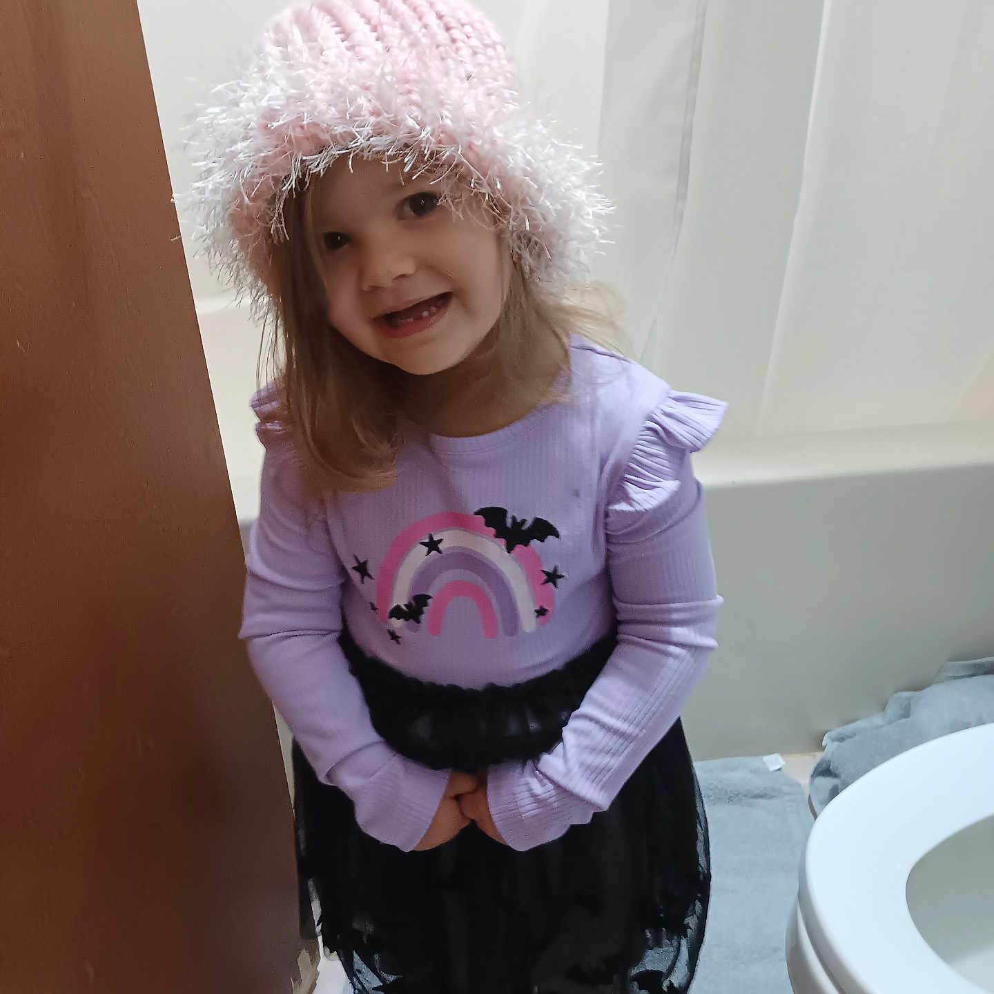 Madelynn is registered to the contest to win money with this photo: bathroom, beanie, bonnet, cap, child, clothing, face, female, footwear, girl, hat, head, indoors, knitwear, longsleeve, person, room, shoe, sweater, toilet