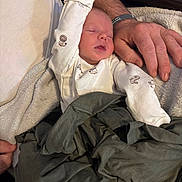 Brandon joined the competition — help win amazing prizes! baby, sleeping, onesie, animal_print, blanket, adult_hand, arm, clothing, cozy, rest, indoor, comfort, skin, person, fabric, texture, couch, relaxation, nap, warmth