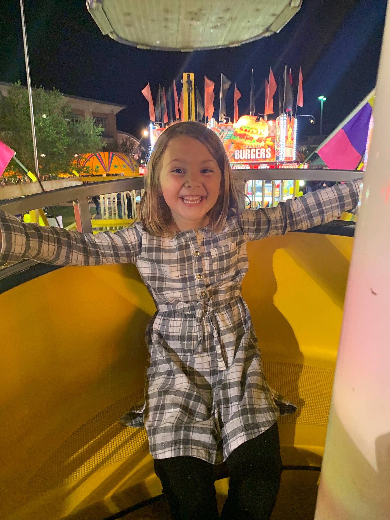 Kiley is registered to the contest to win money with this photo: amusement_park, amusement_ride, child, fair, fun, joy, leisure, park, person, recreation, smile, toddler, tourist_attraction, vacation, yellow