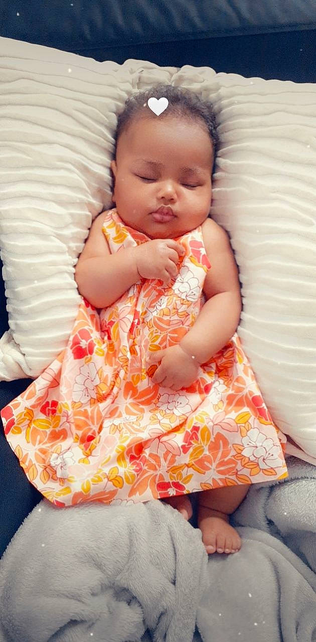 Aaliyah a rejoint le concours — aidez-le/la à gagner de superbes lots ! baby, baby_toddler_clothing, cheek, comfort, dress, eye, face, facial_expression, hairstyle, head, human_body, lip, mouth, orange, organ, person, pink, skin, sleeve, textile