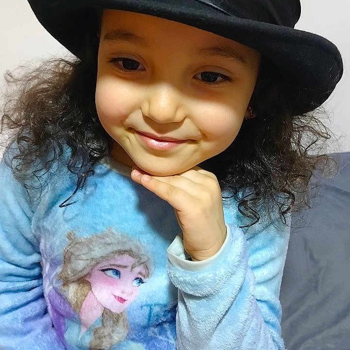 Lin participe au concours pour gagner de l'argent avec cette photo : black_hat, casual, child, childhood, cozy, curly_hair, cute, fashion, frozen_character, girl, hand_on_chin, happy, hat, indoor, long_sleeves, pajamas, person, portrait, smile, young