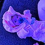 baby, pacifier, pink_bunny_outfit, fluffy_clothing, infant, lying_down, soft_texture, hand, tattoo, closeup, cute, child, indoors, face, expression, cozy, clothing, person, resting, babywear