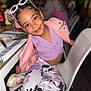 child, girl, smiling, sunglasses, pink_jacket, purple_top, patterned_pants, sitting, chair, restaurant, table, plate, fork, happy, indoor, fashion, casual, person, cute, playful