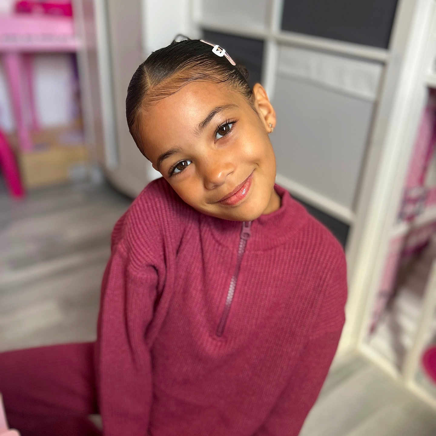 Cattleya is registered to the contest to win money with this photo: blurry_background, casual, child, childhood, cozy, cute, face, fashion, furniture, girl, hairclip, happy, indoors, knitwear, maroon, person, portrait, room, smile, young