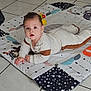 baby, child, infant, floor, tile_floor, play_mat, clothing, white_outfit, brown_patches, indoor, curious, lying_down, hands, face, head, looking_up, soft_toys, patterned_mat, home, cute