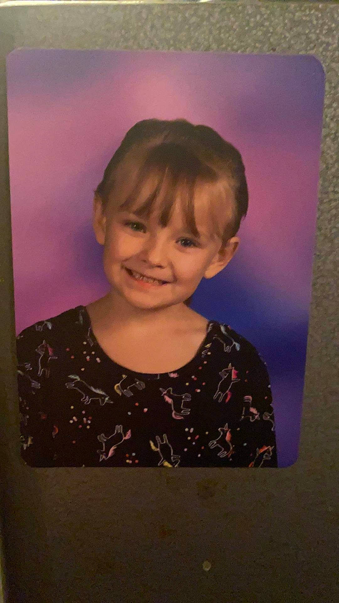 Arya is registered to the contest to win money with this photo: art, bangs, brown_hair, cheek, child, chin, eyebrow, fun, hair, happy, iris, joy, pattern, person, pink, rectangle, sleeve, smile, t_shirt, toddler