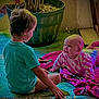 Marcy is registered to the contest to win money with this photo: baby, child, toddler, carpet, blanket, plant, indoor, floor, sitting, lying, clothing, playtime, cute, smiling, home, colorful, person, interaction, young_child, happy