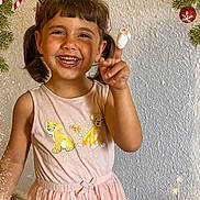 Emily is registered to the contest to win money with this photo: child, girl, smiling, pigtails, bandaged_finger, pink_dress, lion_cubs, holiday_decorations, candy_cane, christmas_ornaments, evergreen_branches, festive, winter_theme, happy, portrait, indoor, cute, person, celebration, joy