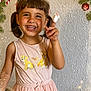 child, girl, smiling, pigtails, bandaged_finger, pink_dress, lion_cubs, holiday_decorations, candy_cane, christmas_ornaments, evergreen_branches, festive, winter_theme, happy, portrait, indoor, cute, person, celebration, joy