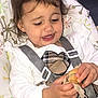 Emily joined the competition — help win amazing prizes! toddler, child, high_chair, food, sandwich, happy, smiling, indoor, clothing, white_shirt, plaid_dress, seatbelt, messy, hands, face, brown_hair, person, baby, eating, cute