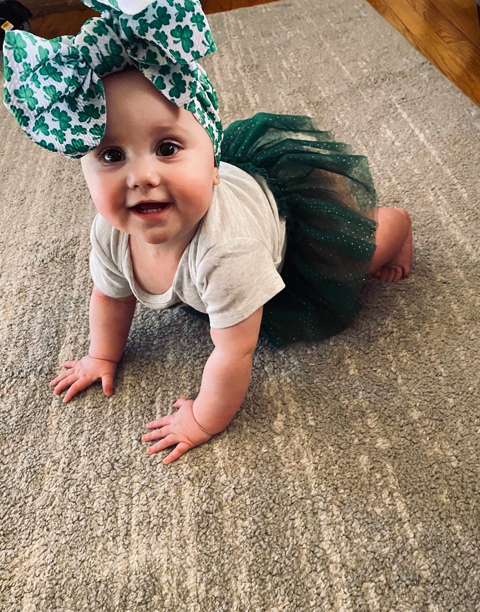 Mckenna is registered to the contest to win money with this photo: baby, baby_toddler_clothing, cap, comfort, cool, crawling, finger, floor, flooring, grass, hand, happy, hardwood, headwear, leg, people_in_nature, person, skin, sleeve, smile