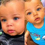 Sevyn is registered to the contest to win money with this photo: baby, toddler, child, face, blue_eyes, curly_hair, portrait, close_up, clothing, hand, person, cute, expression, indoor, skin, young_child, childhood, holding, vibrant, split_screen