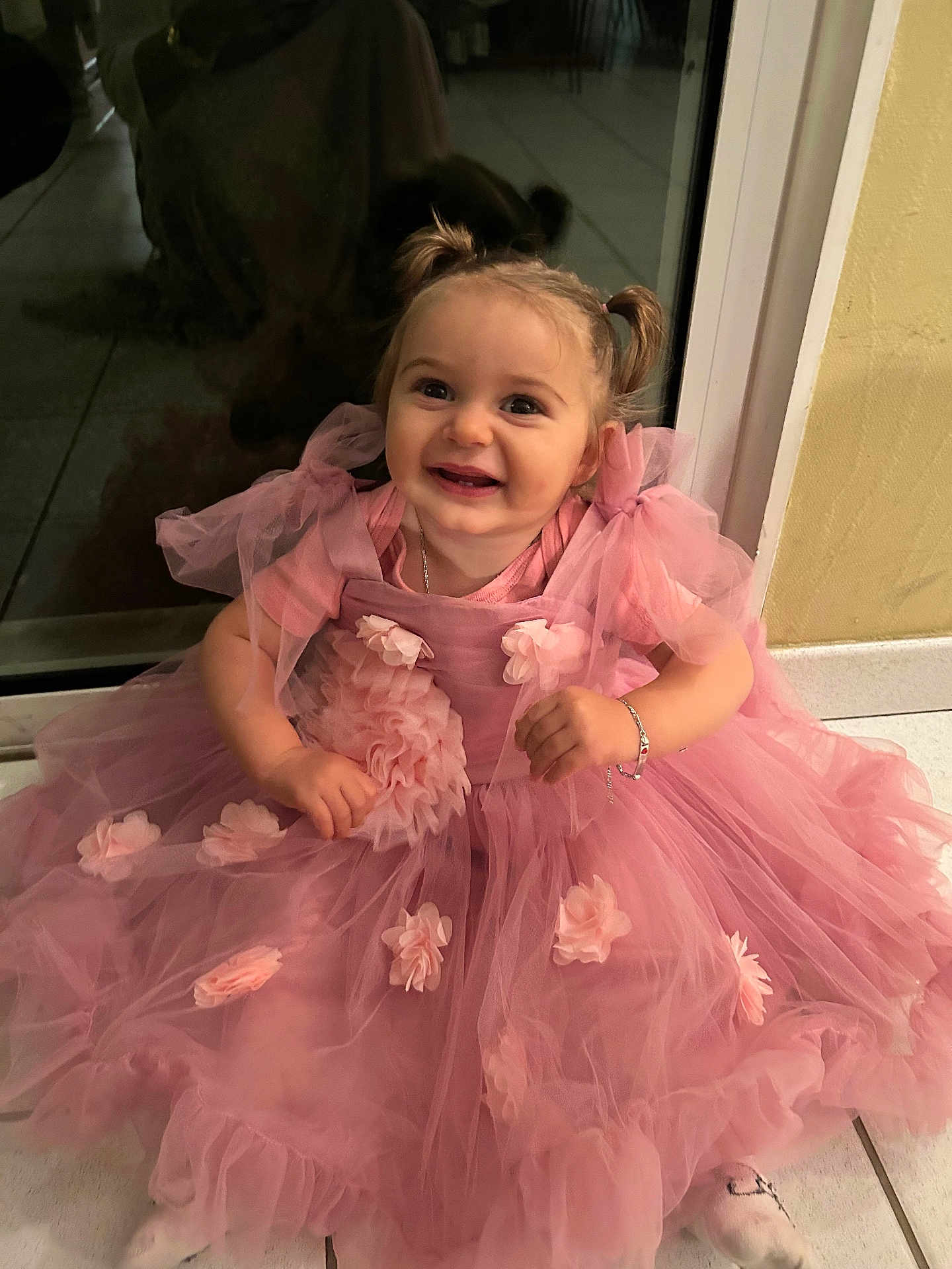 Mayhanna participe au concours pour gagner de l'argent avec cette photo : toddler, child, pink_dress, flower_appliques, pigtails, smile, happy, indoor, floor, glass_door, reflection, bracelet, cute, portrait, sitting, baby, young_child, celebration, fashion, adorable