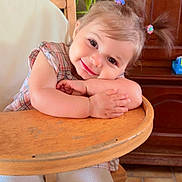 Mayhanna participe au concours pour gagner de l'argent avec cette photo : child, cozy, cute, face, floor_tiles, hair_clips, hands, happy, highchair, home, indoor, person, pigtails, plaid_shirt, plant, portrait, smiling, toddler, white_pants, wooden_furniture