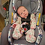 baby, car_seat, infant, clothing, onesie, face, straps, safety, indoors, cute, child, person, expression, seat, fabric, pattern, pink, blue, newborn, head