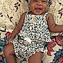 Storm is registered to the contest to win money with this photo: baby, infant, smiling, leopard_print, headband, sandals, quilt, floral_pattern, cute, happy, child, clothing, footwear, portrait, lying_down, indoors, fabric, button, person, closeup