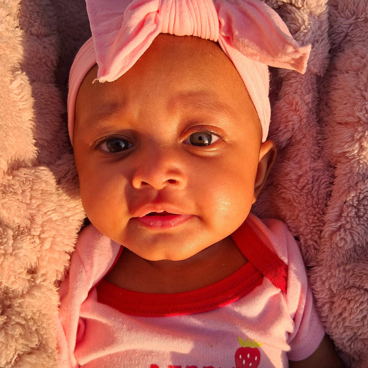 Jericha joined the competition — help win amazing prizes! baby, blanket, bow, child, closeup, clothing, cute, eyes, face, indoors, infant, mouth, newborn, person, pink_headband, portrait, skin, soft_texture, strawberry_print, warm_light