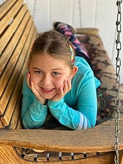 Kassandra is registered to the contest to win money with this photo: blond, child, face, facial_expression, fun, grass, hairstyle, happy, hardwood, head, joy, leisure, person, recreation, sitting, skin, smile, snapshot, toddler, tree