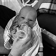 Waylon joined the competition — help win amazing prizes! baby, newborn, feeding, bottle, hand, hospital_wristband, blanket, striped_towel, black_and_white, indoor, person, infant, care, feeding_bottle, wrapped, close_up, face, portrait, resting, comfort