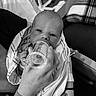 baby, newborn, feeding, bottle, hand, hospital_wristband, blanket, striped_towel, black_and_white, indoor, person, infant, care, feeding_bottle, wrapped, close_up, face, portrait, resting, comfort