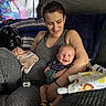 baby, woman, smile, couch, blanket, towel, indoor, happy, holding, child, person, clothing, pattern, fabric, light, shadow, tattoo, sock, remote_control, home