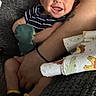 Waylon joined the competition — help win amazing prizes! baby, smiling, infant, person, arm, plush_toy, blanket, clothing, striped_shirt, yellow_socks, tattoo, holding, couch, happy, indoor, closeup, skin, expression, comfort, resting