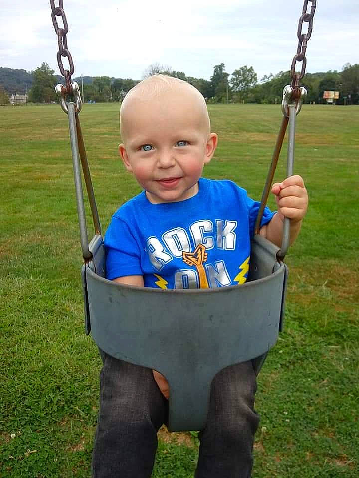 Braxtyn is registered to the contest to win money with this photo: child, outdoor_play_equipment, person, playground, public_space, smile, swing, toddler