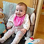 Skyla-Jayne joined the competition — help win amazing prizes! baby, infant, smiling, pink_bib, white_outfit, toy, stuffed_animal, cushion, indoor, child, cute, floor, sitting, happy, face, head, person, plush_toy, home, cozy