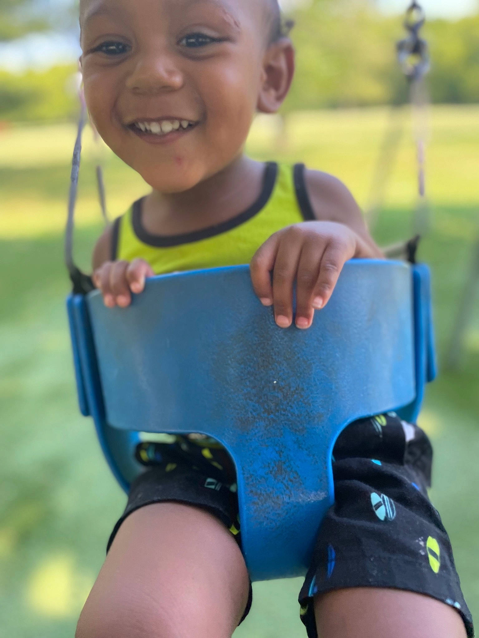 Kamari is registered to the contest to win money with this photo: arm, baby_toddler_clothing, blue, cool, finger, grass, green, hand, happy, headwear, joy, leisure, light, people_in_nature, person, photograph, skin, sleeve, smile, swing