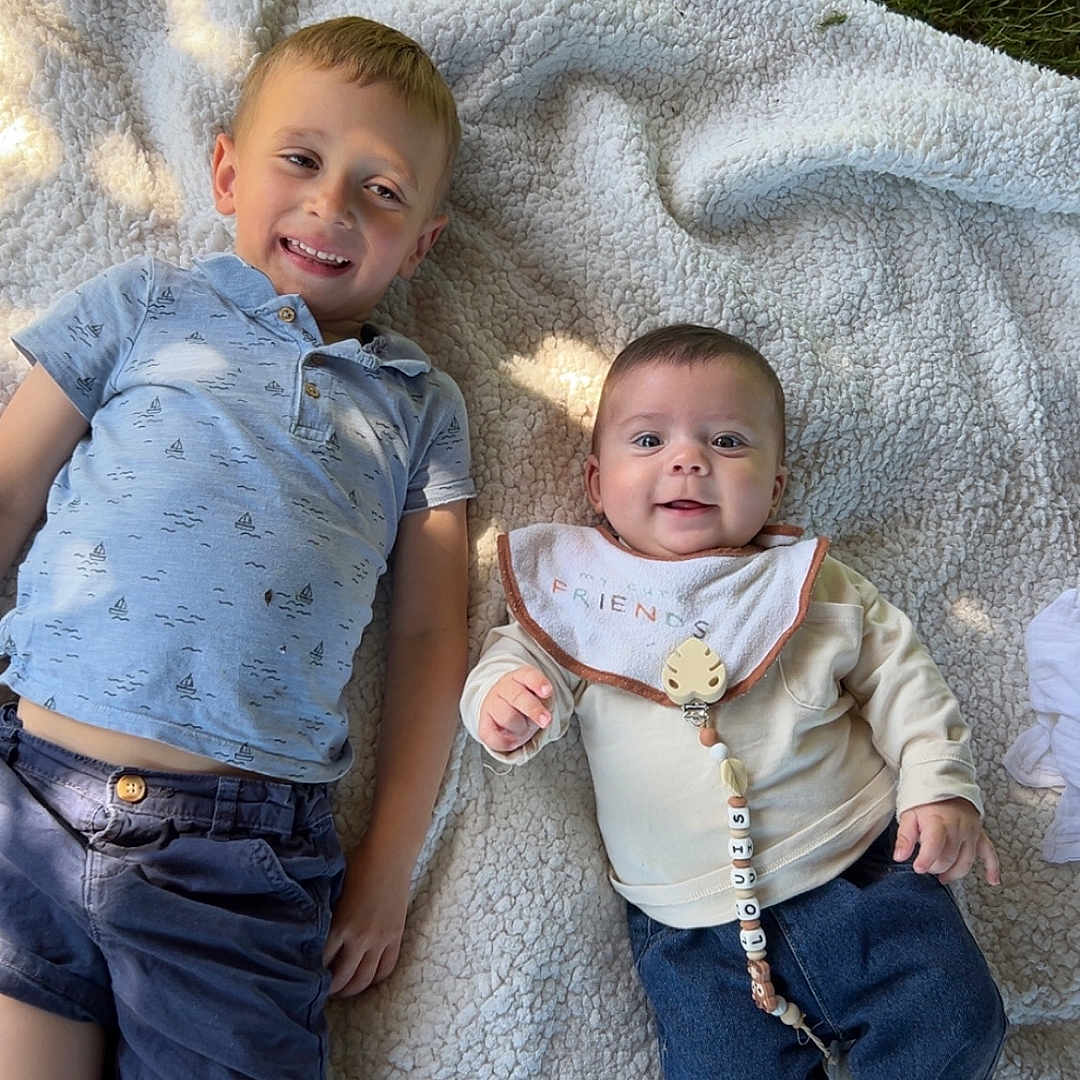 Louis participe au concours pour gagner de l'argent avec cette photo : baby, baby_bib, barefoot, blanket, casual_clothing, child, cute, family, grass, happy, nature, outdoor, playful, portrait, relaxing, shorts, sitting, smiling, sunlight, toddler
