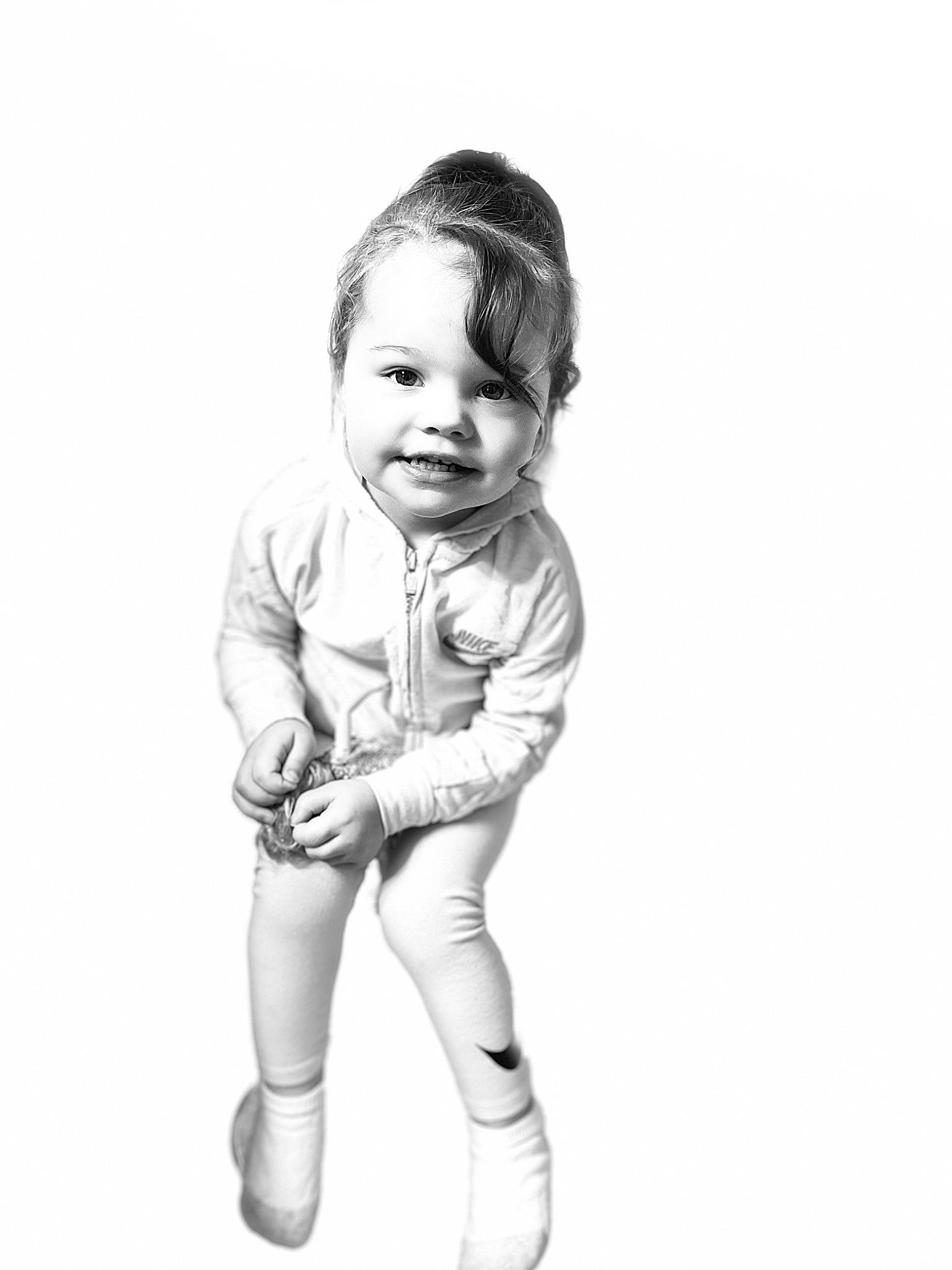 Lina is registered to the contest to win money with this photo: baby, baby_toddler_clothing, child, elbow, flash_photography, foot, gesture, hand, happy, human_leg, joy, knee, monochrome, monochrome_photography, person, shorts, sitting, sleeve, smile, thigh