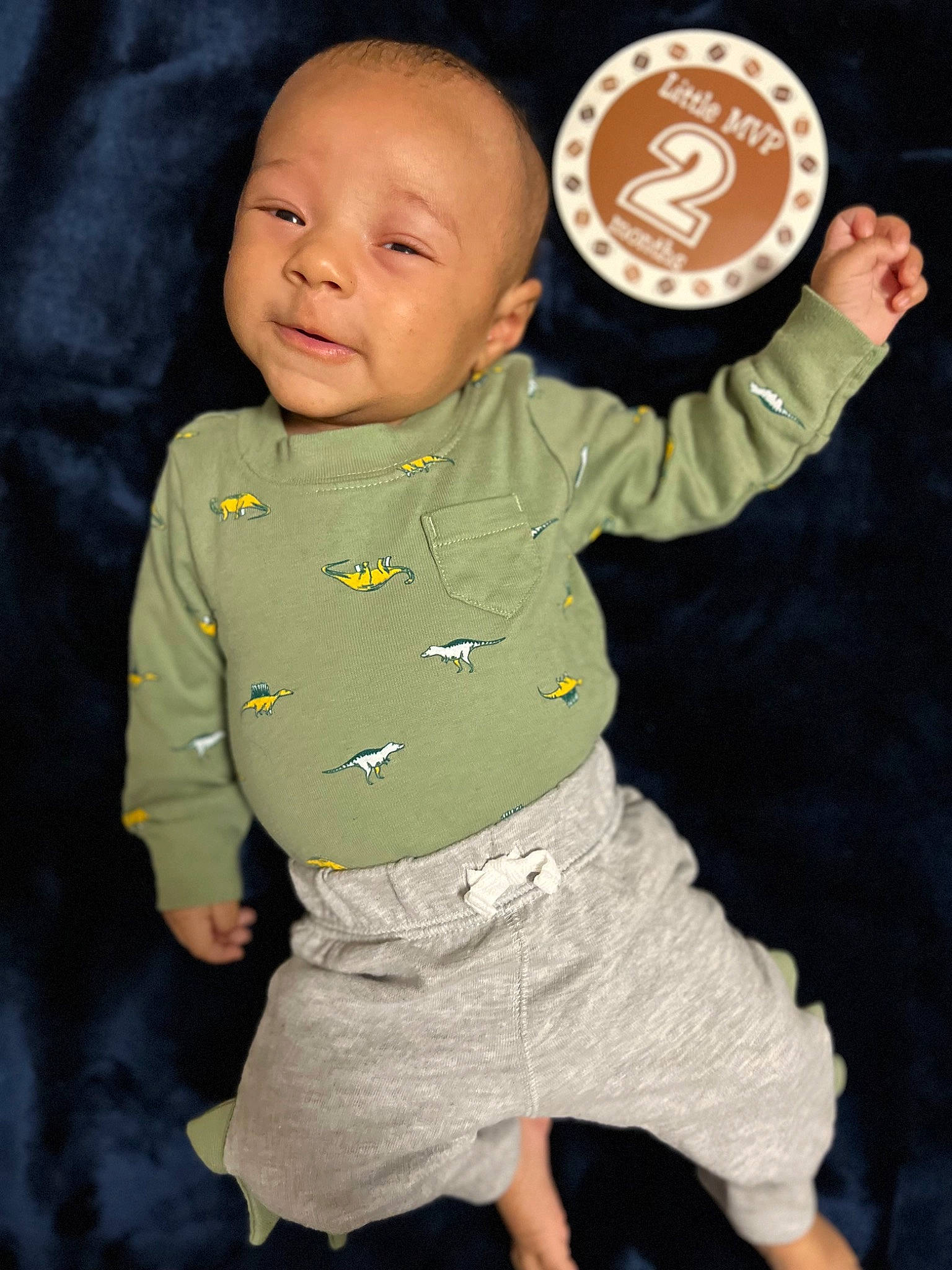 Khyrie is registered to the contest to win money with this photo: arm, baby, baby_products, baby_toddler_clothing, button, cheek, child, face, finger, gesture, hand, happy, head, human_body, organ, pattern, person, sitting, sleeve, t_shirt