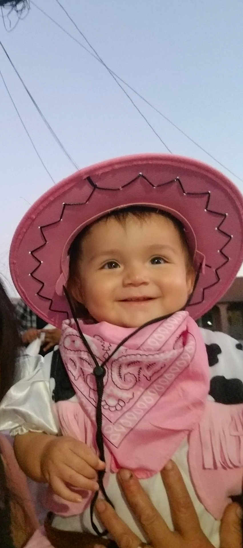 Alejandra is registered to the contest to win money with this photo: toddler, child, smile, cowboy_hat, pink, bandana, costume, happy, outdoor, person, hand, face, evening, sky, clothing, portrait, cute, baby, headwear, fun