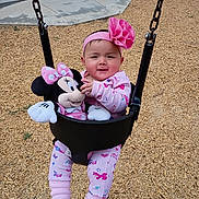 Alejandra joined the competition — help win amazing prizes! baby, child, swing, playground, plush_toy, minnie_mouse, pink_clothing, headband, flower, outdoor, wood_chips, happy, smile, toddler, chain, seat, person, toy, cute, fun