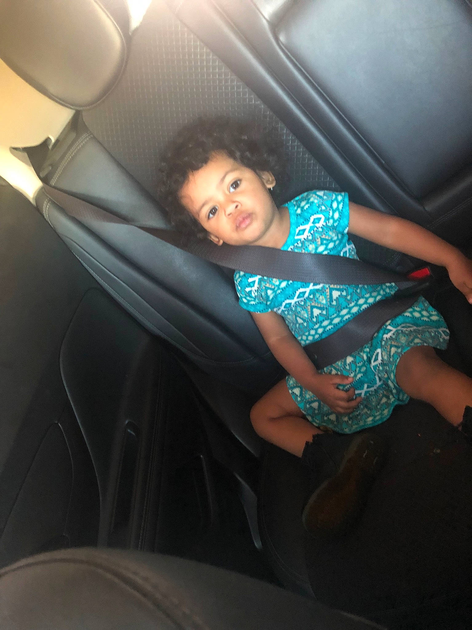Lexa is registered to the contest to win money with this photo: auto_part, car, car_seat, child, fun, leg, luxury_vehicle, person, sitting, smile, textile, toddler, vacation