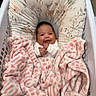 baby, blanket, child, comfort, cozy, cushion, cute, face, floral_pattern, happy, indoor, infant, laundry_basket, person, pink, portrait, resting, smiling, soft, white